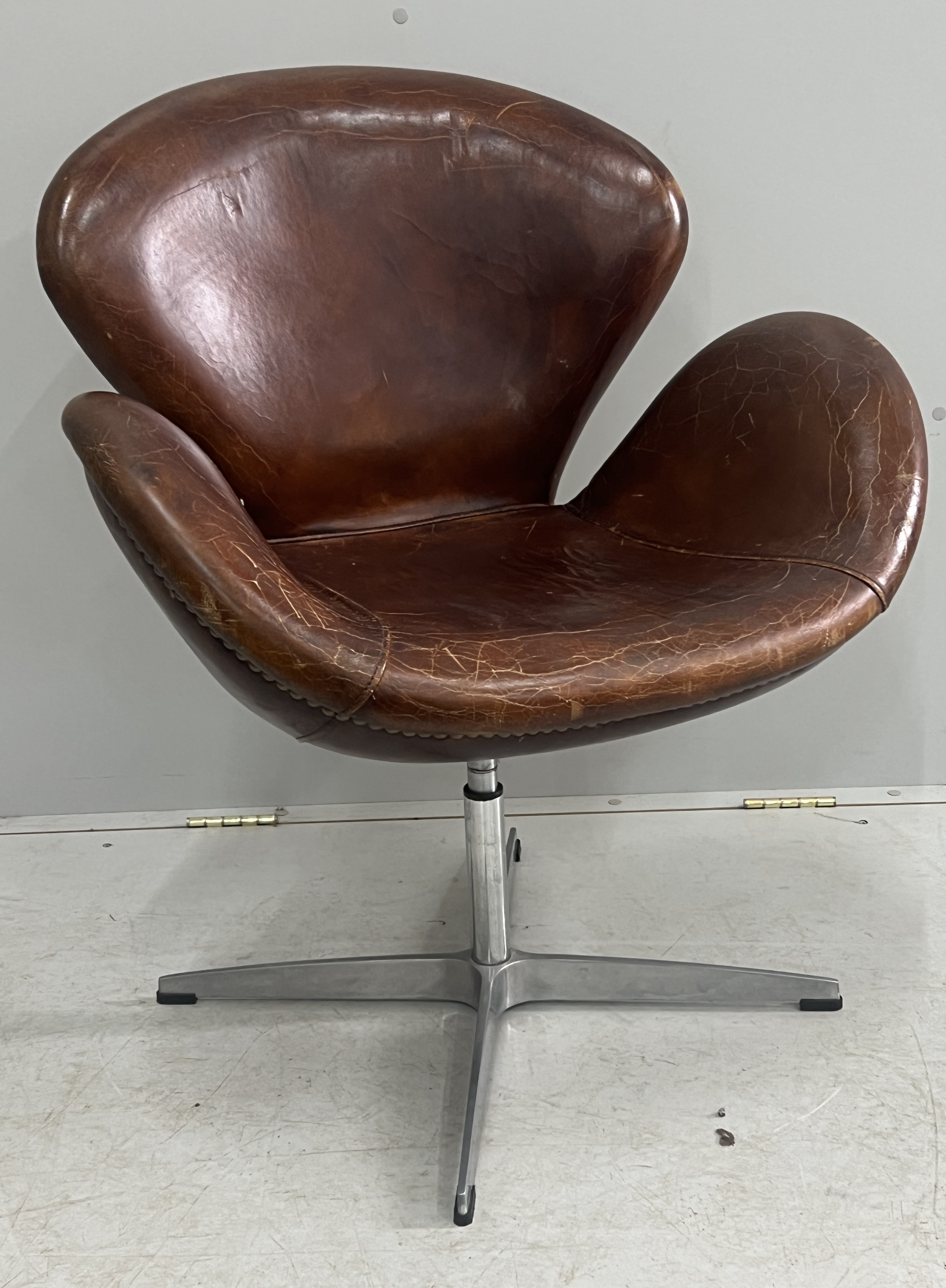 A tan leather petal chair, width 70cm, depth 42cm, height 84cm
